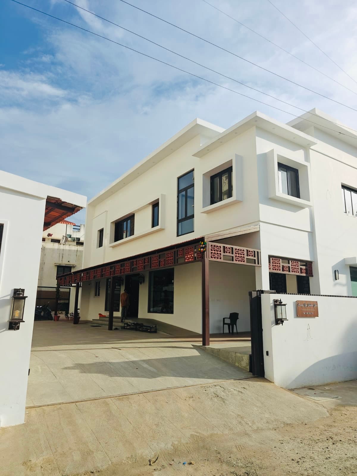 The open gate with the clinic beyond it and the nameplate on the wall