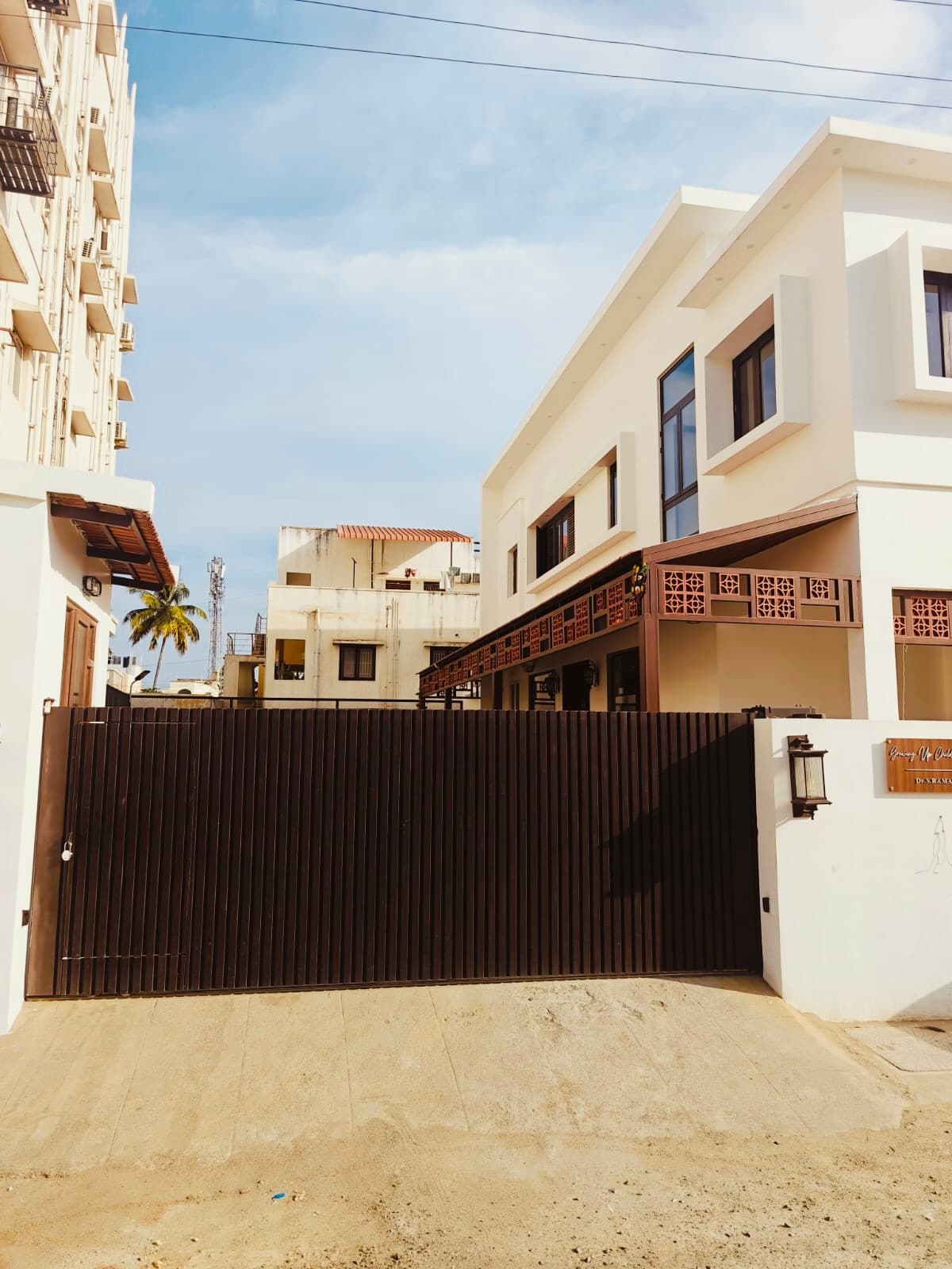 The clinic gate seen from the street, the building rising behind the compound wall